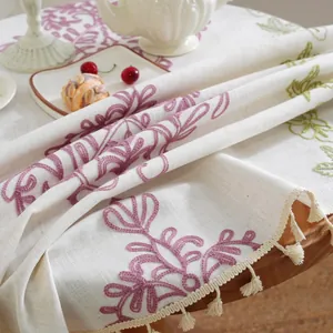 Primer plano de mantel jacquard bohemio con bordado floral púrpura y borlas
