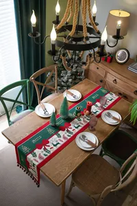 Detailed close-up of festive Christmas table runner featuring deer and tassels decor