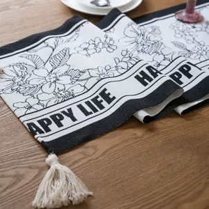 Camino de mesa moderno en blanco y negro con flores, borlas y texto de Happy Life