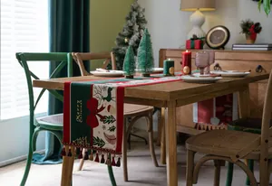 Detail of Christmas table runner with deer patterns and festive tassel decorations