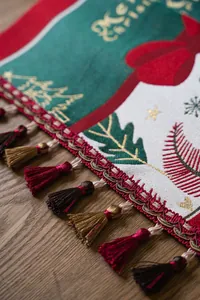 Detail of Christmas table runner with Merry Christmas text and festive tassel fringe