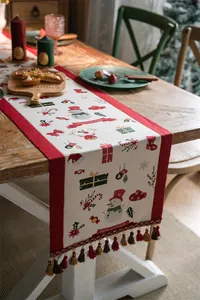 Detailed shot of Christmas table runner with snowman patterns and colorful tassels