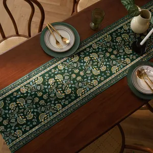 Gedetailleerde retro tafelloper met bloemenjacquard en kwastjes op houten tafel