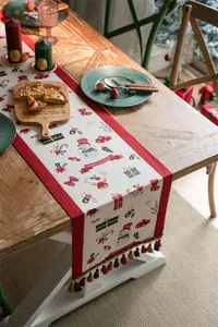 Close-up of Christmas table runner with snowman, deer patterns and colorful tassels
