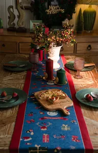Detail of Christmas table runner with snowman and reindeer jacquard and festive tassels