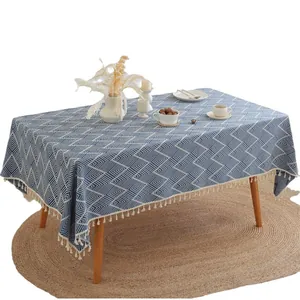 Blue wave stripe rectangular jacquard tablecloth with white tassels on a wooden table