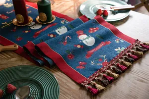 Detailed view of jacquard table runner with snowman, reindeer patterns and colorful tassels