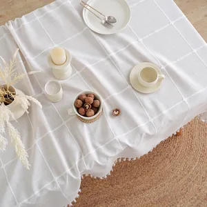 Macro-opname van een crèmewit geruit tafelkleed met franjes en boho-stijl decoratie