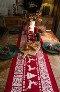 Detail of red Christmas table runner with white reindeer and jacquard snowflake patterns