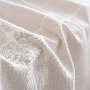 Macro-opname van geborduurd linnen-look tafelkleed met focus op stof en textuur
