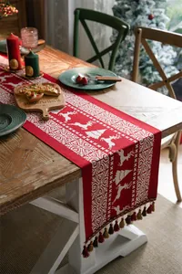 Detailed knit texture of red Christmas table runner with white reindeer and snowflake motifs