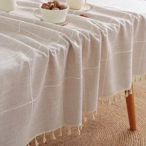 Detail van beige geruit linnen tafelkleed met decoratieve witte kwastjes aan de rand
