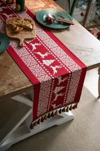 Detail of Christmas table runner with jacquard reindeer patterns and festive tassels