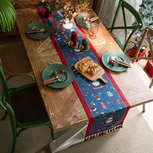 Navy blue Christmas table runner with snowman reindeer motifs and festive tassels