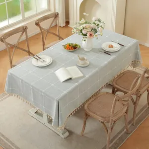 Minimalist light blue checkered tablecloth with tassels on a rectangular dining table