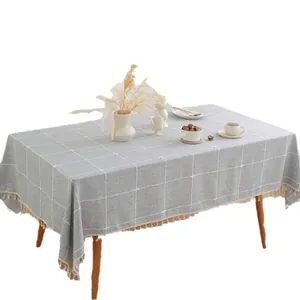 Grey checkered rectangle tablecloth with tassels in a minimalist Nordic style home setting