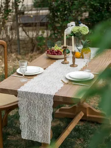 Detailed texture of white lace table runner with floral patterns on rustic wood