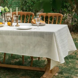 Rechthoekig tafelkleed met linnen textuur en verticale strepen op houten buitentafel