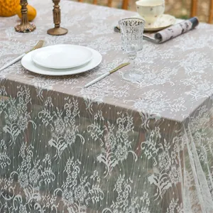 Detailed close-up of French vintage white lace tablecloth with floral embroidery patterns
