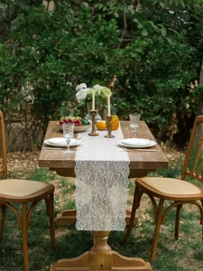 Close-up of white floral lace table runner with French hollow embroidery on a wooden table