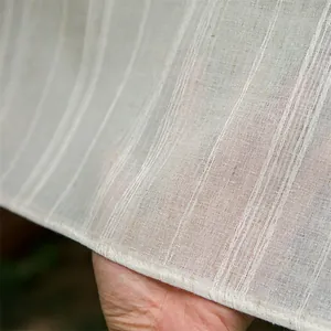 Macro detail van ademende beige linnen tafelkleed stof met verticale streep textuur