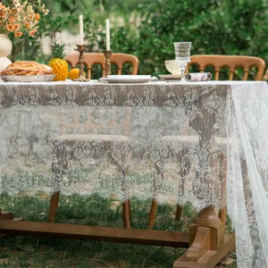 Close-up of white vintage lace tablecloth featuring delicate hollow floral patterns