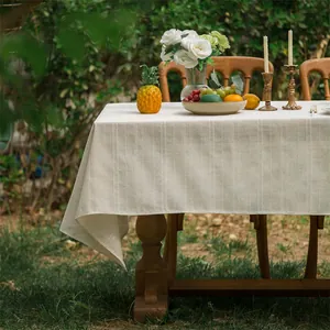 Detail van havermout linnen tafelkleed met verticale strepen op houten tafel buiten