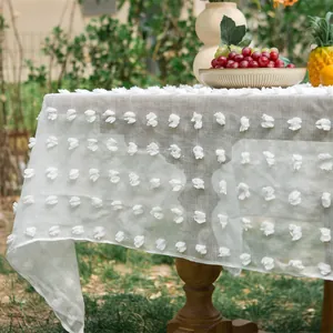 Detailtextur der weißen Netztischdecke mit weich getufteten floralen Stickmustern