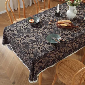 Detail der Vintage-Blumendecke mit braun-schwarzen Mustern und weißem Spitzenbesatz