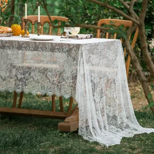 Detailed macro of white lace tablecloth featuring delicate floral patterns and eyelash lace edges