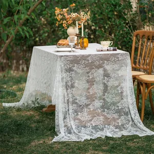 Close-up of white floral lace tablecloth detail showing elegant hollowed patterns