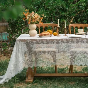 Detail of white lace tablecloth showing intricate floral crochet and wavy scalloped edges