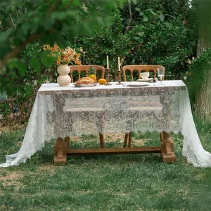 Detailed close-up of white lace tablecloth with floral crochet patterns and scalloped edges