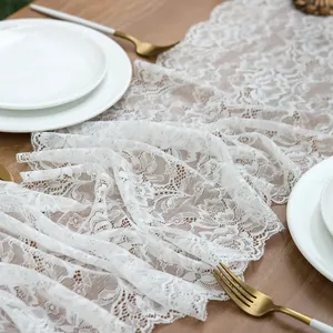 Elegant white lace table runner with floral patterns on a wooden dining table