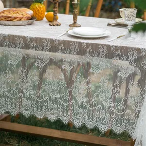 Close-up of white lace tablecloth with floral hollow patterns and delicate eyelash edges