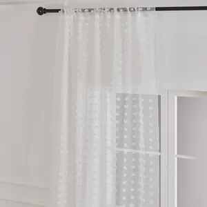 White semi-sheer curtain with small pom-poms on a black rod for living room decor