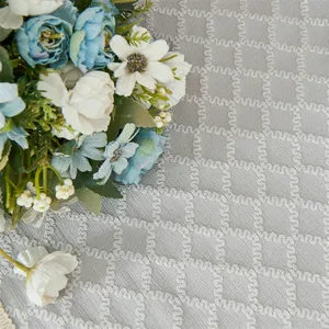 Detailansicht grauer Polyester-Jacquardstoff mit Rautenmuster und dekorativen Fransen