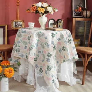 Detail of vintage floral cotton linen tablecloth with elegant white lace border trim