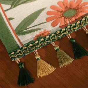 Dettaglio del runner da tavola jacquard con margherite arancioni e frange intrecciate