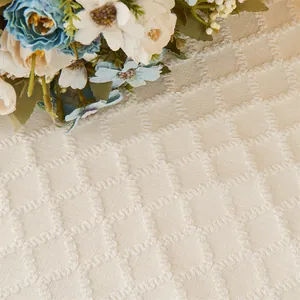 Detailansicht von cremefarbenem Jacquard-Stoff mit geometrischem Muster und Quastenverzierung