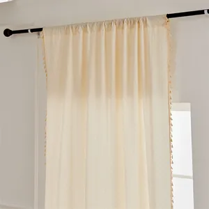 Detail der cremefarbenen Jacquard-Verdunkelungsvorhänge mit Fransen und Stangentasche