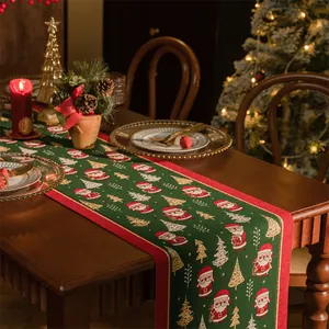 Dettaglio del runner da tavola natalizio con motivi di Babbo Natale e alberi su legno