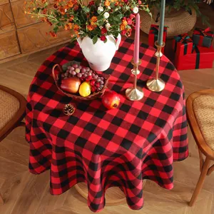 Top view of red and black buffalo plaid round tablecloth with festive holiday decor