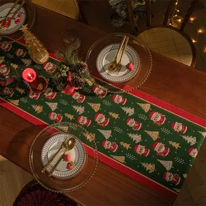 Dettaglio di runner da tavola natalizio verde con motivi di Babbo Natale e alberi