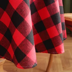 Macro shot of red and black buffalo plaid Christmas tablecloth with white stitched hem