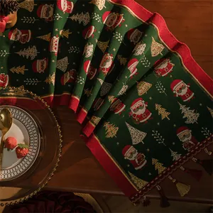 Dettaglio del runner da tavola natalizio con motivi Babbo Natale e nappe eleganti