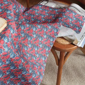 Detail of premium cotton linen tablecloth featuring vintage red poppy and blue floral patterns