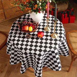 Close-up of circular black and white checkered tablecloth with a cozy holiday scene