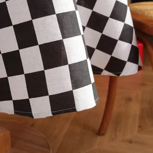 Detailed view of black and white checkered tablecloth featuring clean stitched edges