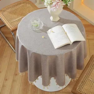 Nahaufnahme einer runden taupefarbenen Tischdecke mit eleganten Fransen und Textur